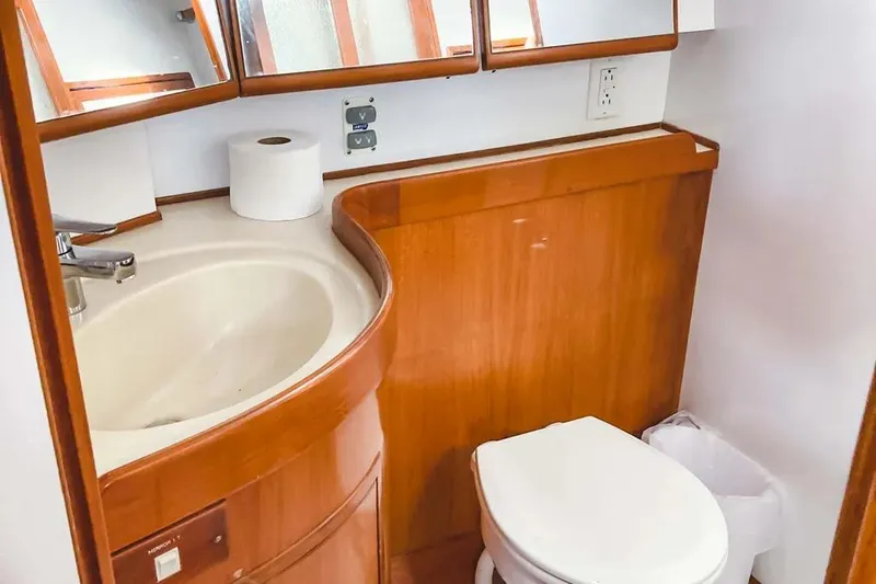 Violina Yacht Photos Pics Bathroom interior of 1999 Hylas 54 yacht with wooden cabinetry and modern fixtures.