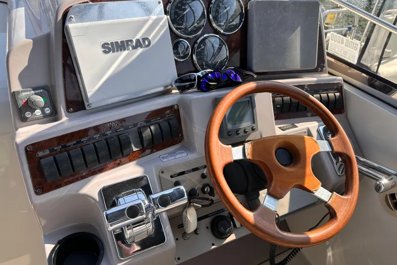  Yacht Photos Pics Control panel of a 2001 Regal Commodore 4160 boat with wooden steering wheel.