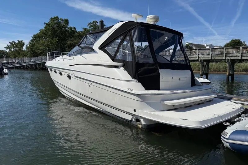  Yacht Photos Pics 2001 Regal Commodore 4160 yacht docked by a wooden pier on a sunny day.