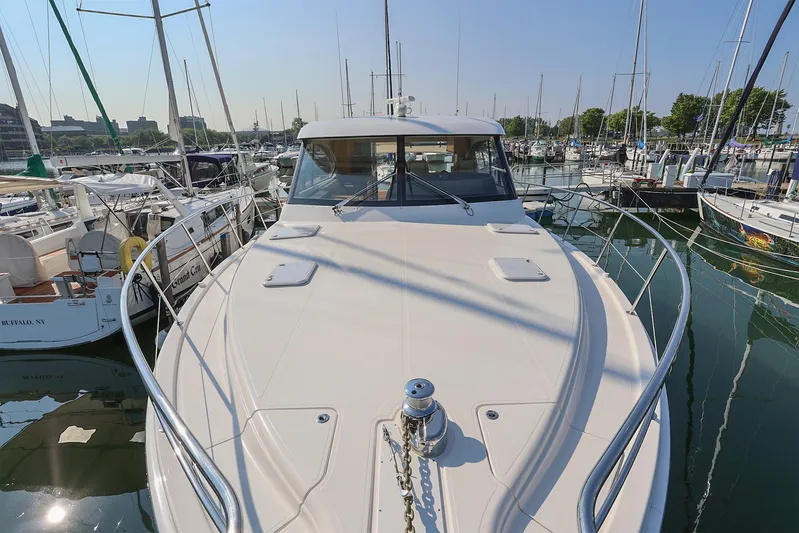  Yacht Photos Pics 2016 Riviera 525 SUV yacht docked in a marina, surrounded by other boats.
