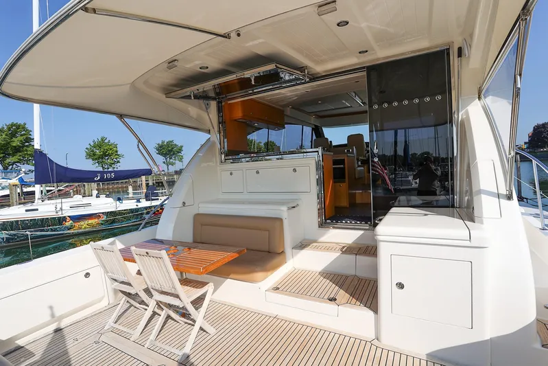  Yacht Photos Pics 2016 Riviera 525 SUV yacht with spacious deck and seating area at a marina.