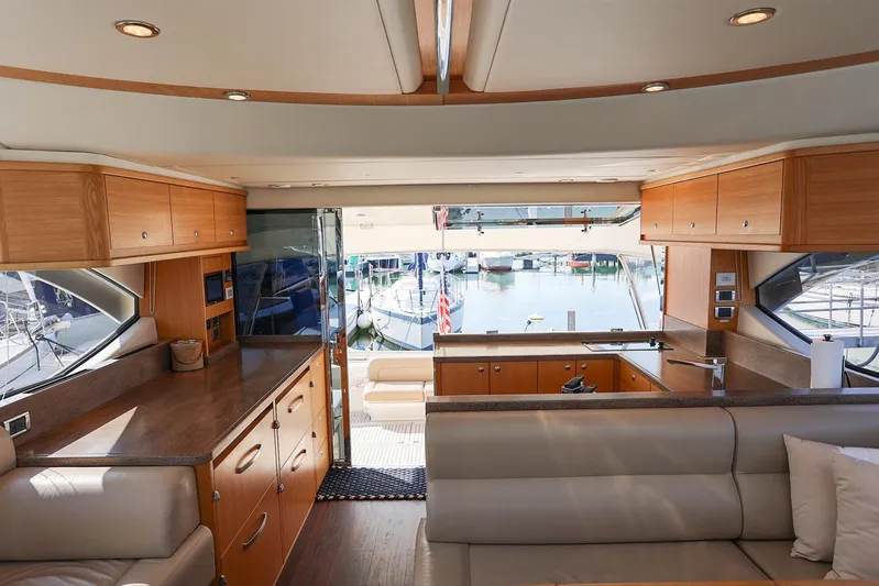  Yacht Photos Pics Interior of 2016 Riviera 525 SUV yacht with modern wood cabinetry and marina view.