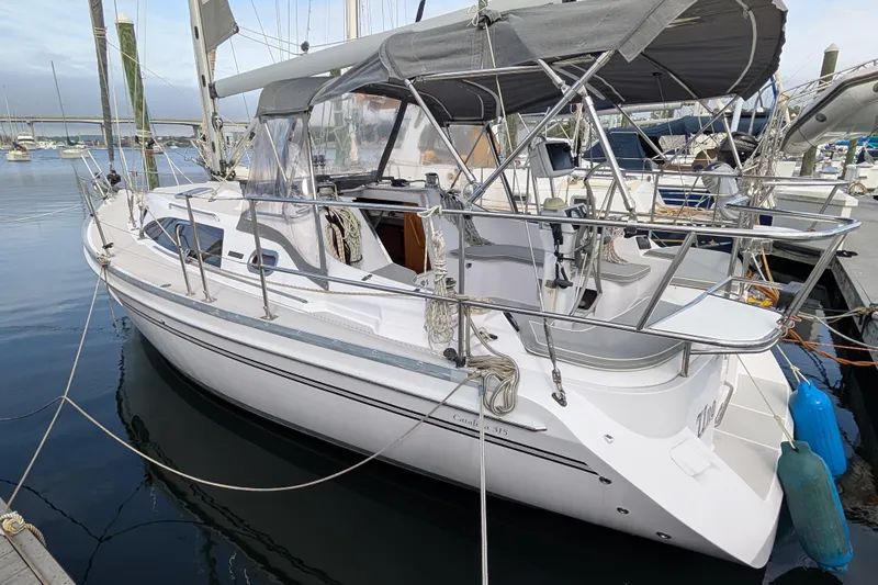 Uno Mas Yacht Photos Pics 2021 Catalina 315 sailboat docked in marina, featuring sleek design and protective canopy.