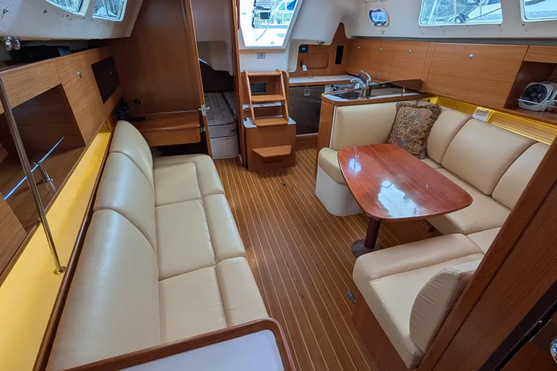 Uno Mas Yacht Photos Pics 2021 Catalina 315 yacht interior with elegant wood finish and comfortable seating.