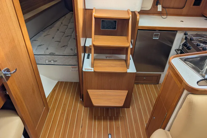 Uno Mas Yacht Photos Pics Interior of a 2021 Catalina 315 sailboat with wood finish and compact kitchen.