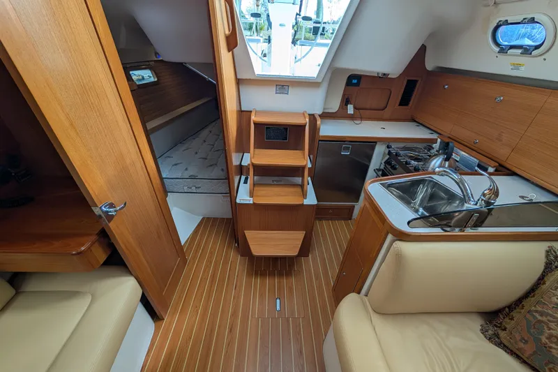 Uno Mas Yacht Photos Pics Interior of 2021 Catalina 315 sailboat with kitchen, seating, and sleeping area.
