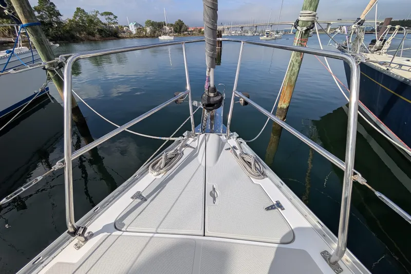 Uno Mas Yacht Photos Pics Bow of 2021 Catalina 315 sailboat docked in a serene marina setting.