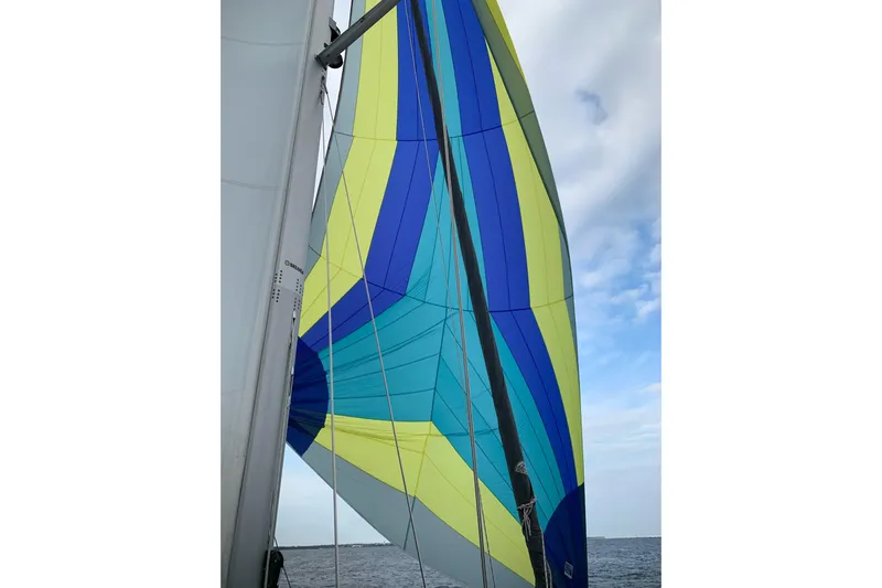 Uno Mas Yacht Photos Pics Colorful sail of 2021 Catalina 315 yacht against blue sky and ocean backdrop.
