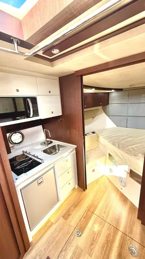  Yacht Photos Pics 2022 Evolve 400HT yacht interior with kitchenette and cozy sleeping area.