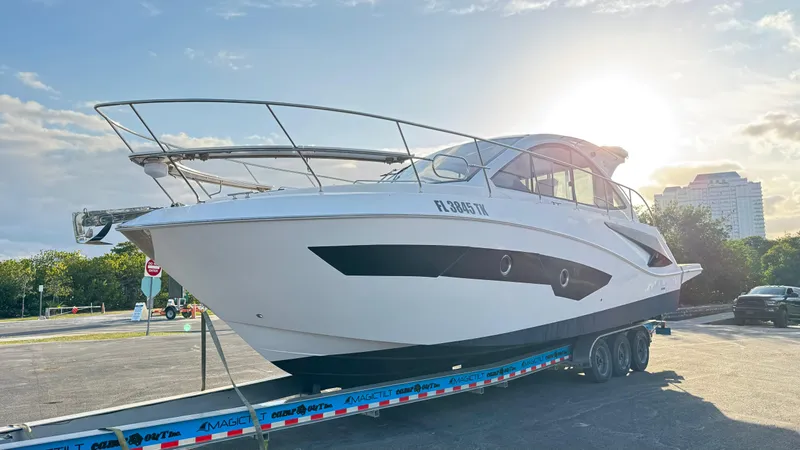  Yacht Photos Pics Evolve 400HT 2022 yacht on trailer, sunlit background, parked in urban setting.
