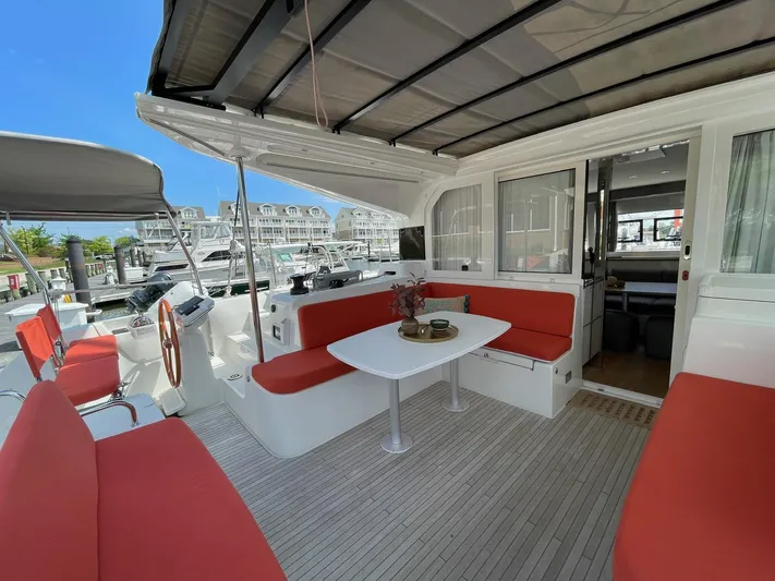 Artemis Yacht Photos Pics Spacious 2022 Excess 12 catamaran with red seating, docked at a marina.