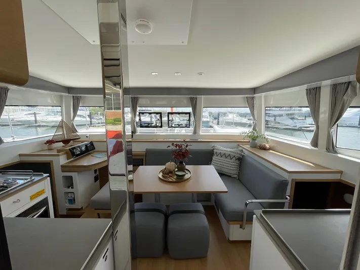Artemis Yacht Photos Pics Luxurious interior of 2022 Excess 12 catamaran with modern dining area and panoramic windows.