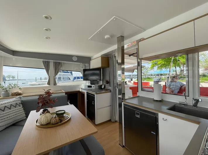 Artemis Yacht Photos Pics Modern interior of 2022 Excess 12 catamaran with kitchen and seating area.