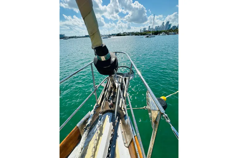 Scout (name Reserved) Yacht Photos Pics Bow of 1971 Alden Boothbay Explorer sailboat on calm water with city skyline.