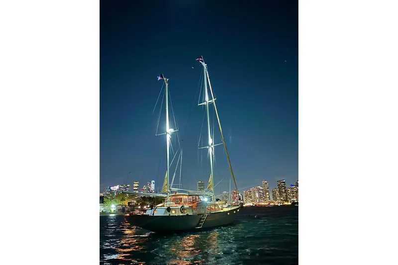 Scout (name Reserved) Yacht Photos Pics Sailboat "Alden Boothbay Explorer" 1971 at night with city skyline backdrop.