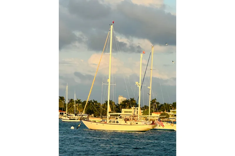 Scout (name Reserved) Yacht Photos Pics Alden Boothbay Explorer 1971 sailboat anchored in a scenic harbor at sunset.