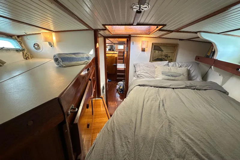 Scout (name Reserved) Yacht Photos Pics Cozy cabin interior of 1971 Alden Boothbay Explorer yacht with bed and wooden furnishings.