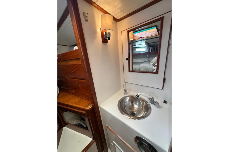 Scout (name Reserved) Yacht Photos Pics 1971 Alden Boothbay Explorer yacht interior with sink, mirror, and wooden cabinetry.
