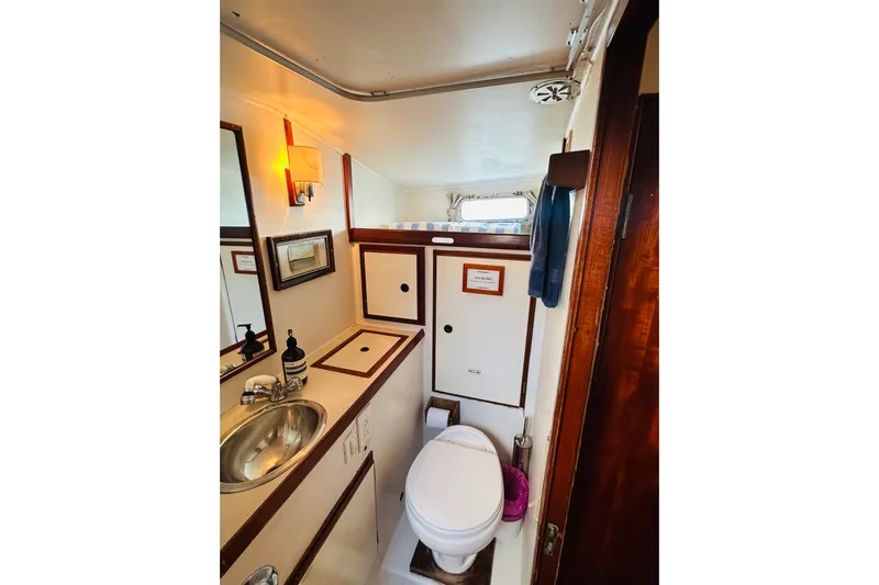 Scout (name Reserved) Yacht Photos Pics 1971 Alden Boothbay Explorer yacht bathroom with sink, toilet, and wooden accents.
