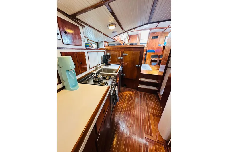 Scout (name Reserved) Yacht Photos Pics Interior of 1971 Alden Boothbay Explorer yacht with wooden cabinetry and compact kitchen.
