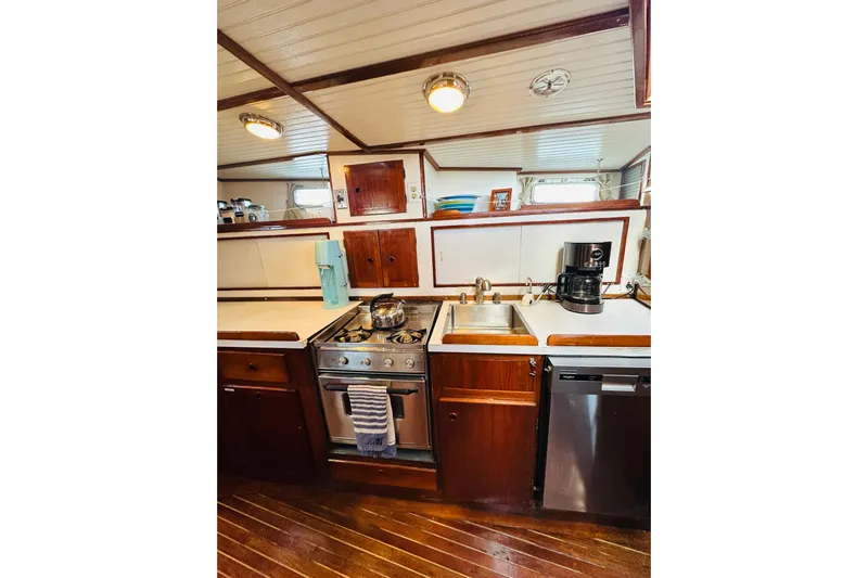 Scout (name Reserved) Yacht Photos Pics 1971 Alden Boothbay Explorer yacht kitchen with stove, sink, and wooden cabinetry.