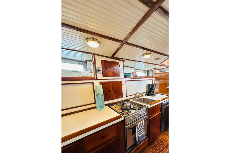 Scout (name Reserved) Yacht Photos Pics 1971 Alden Boothbay Explorer yacht kitchen with wooden cabinetry and modern appliances.