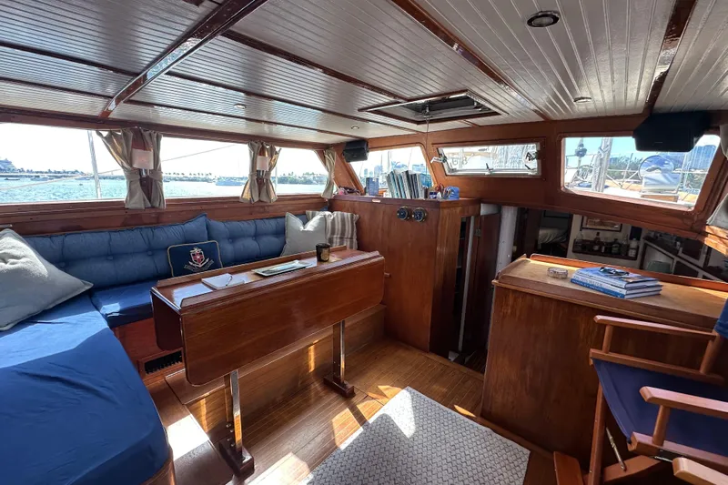 Scout (name Reserved) Yacht Photos Pics Interior of 1971 Alden Boothbay Explorer yacht with wooden furnishings and blue seating.