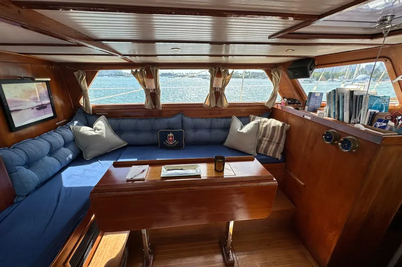 Scout (name Reserved) Yacht Photos Pics Cozy interior of 1971 Alden Boothbay Explorer yacht with blue seating and wooden accents.