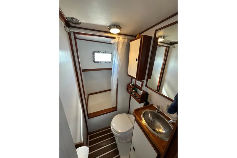 Scout (name Reserved) Yacht Photos Pics 1971 Alden Boothbay Explorer bathroom with shower, sink, and wooden accents.