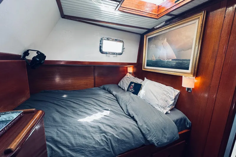 Scout (name Reserved) Yacht Photos Pics Cozy cabin interior of 1971 Alden Boothbay Explorer with wooden paneling and nautical artwork.