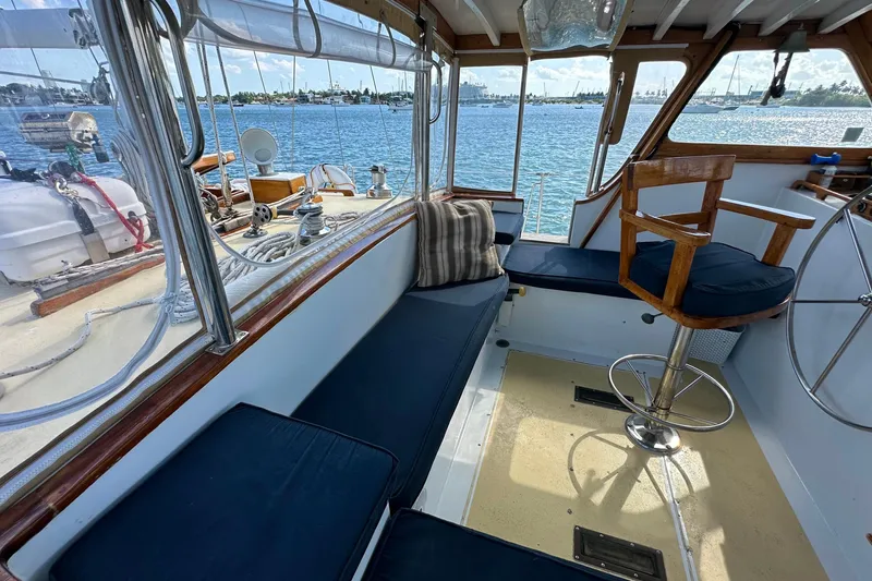 Scout (name Reserved) Yacht Photos Pics 1971 Alden Boothbay Explorer yacht interior with blue seating and wooden helm, overlooking serene waters.