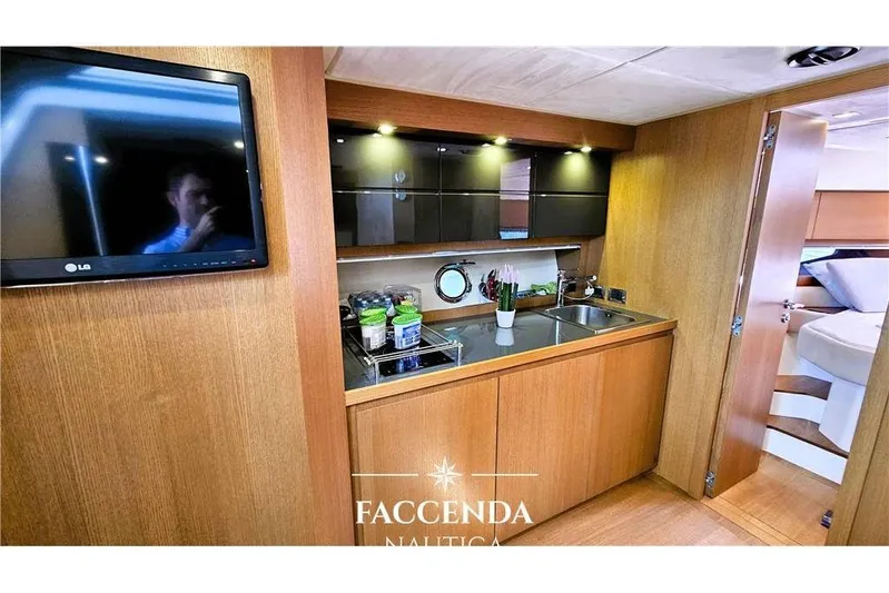  Yacht Photos Pics Modern kitchen interior on 2013 Azimut Atlantis 44 yacht with wood cabinetry and TV.