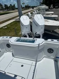  Yacht Photos Pics 2024 Yellowfin 32CC OFFSHORE boat with twin Mercury engines, docked near a road.