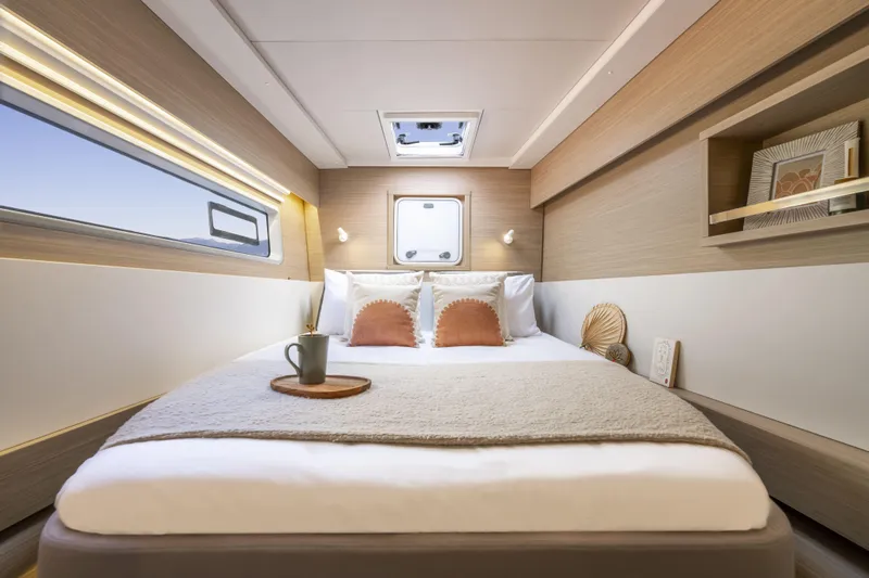  Yacht Photos Pics Luxurious bedroom interior of 2025 Lagoon 43 yacht with modern decor and cozy bedding.