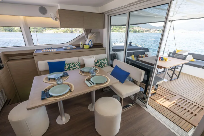  Yacht Photos Pics Luxurious interior of 2025 Lagoon 43 yacht with elegant dining setup and scenic ocean view.