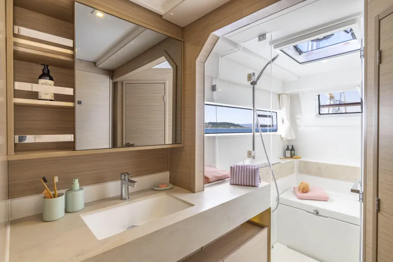  Yacht Photos Pics Luxurious bathroom interior of 2025 Lagoon 43 yacht with modern fixtures and ocean view.