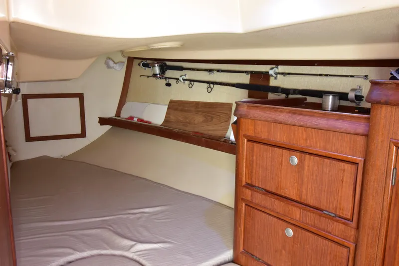 Shibumi Yacht Photos Pics 1995 Island Packet 37 interior cabin with fishing rods and wooden storage drawers.