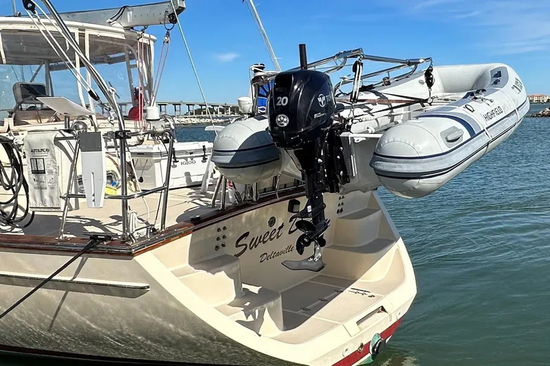 Sweet Dream Yacht Photos Pics 2005 Island Packet 485 sailboat with dinghy and outboard motor on the stern.