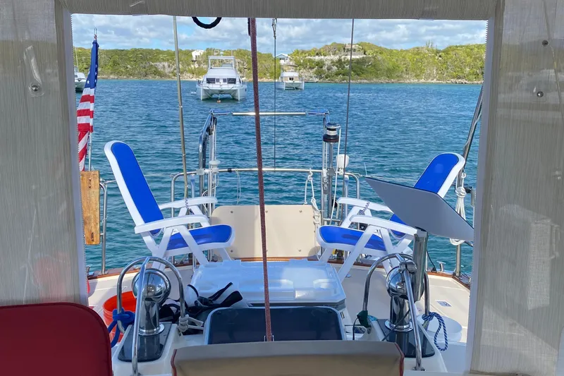 Sweet Dream Yacht Photos Pics Cockpit view of 2005 Island Packet 485 sailboat with blue chairs and scenic water backdrop.