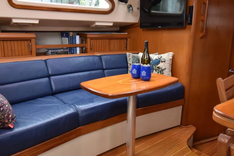 Sweet Dream Yacht Photos Pics Luxurious interior of 2005 Island Packet 485 yacht with blue seating and wooden table.