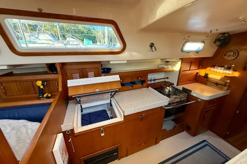 Sweet Dream Yacht Photos Pics 2005 Island Packet 485 yacht interior with kitchen, wooden cabinetry, and appliances.