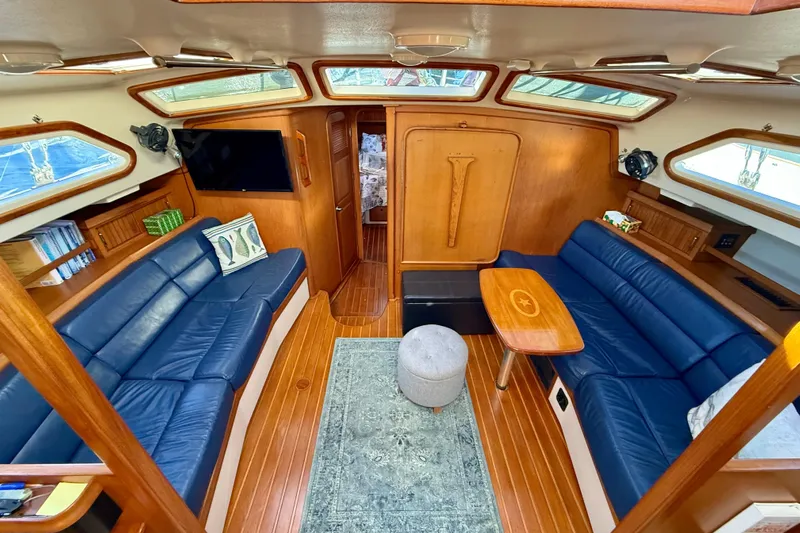 Sweet Dream Yacht Photos Pics Luxurious 2005 Island Packet 485 yacht interior with blue leather seating and wooden accents.