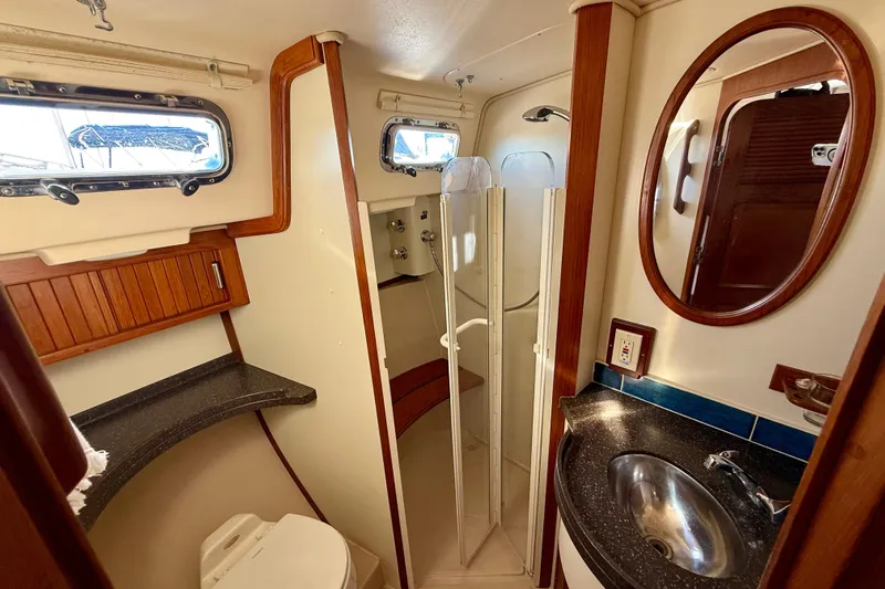 Sweet Dream Yacht Photos Pics 2005 Island Packet 485 yacht bathroom with shower, sink, and wooden accents.