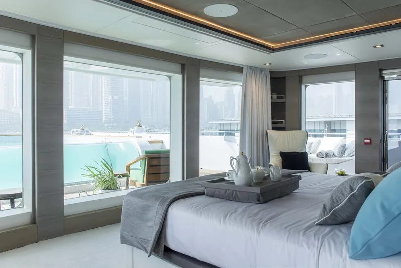 Available 2026 Yacht Photos Pics Luxurious Majesty 175 yacht bedroom with panoramic windows, elegant decor, and cityscape views, 2026 model.