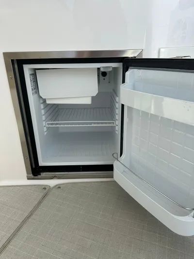  Yacht Photos Pics Open mini fridge on a 2020 Regal 35 Sport Coupe boat, showing interior shelves.