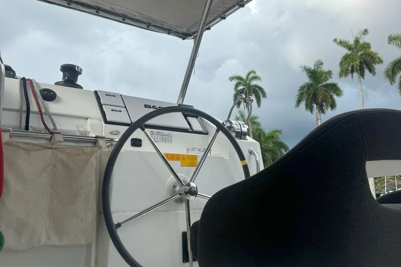 Keola Yacht Photos Pics Steering wheel of 2022 Lagoon 40 catamaran with palm trees in background.