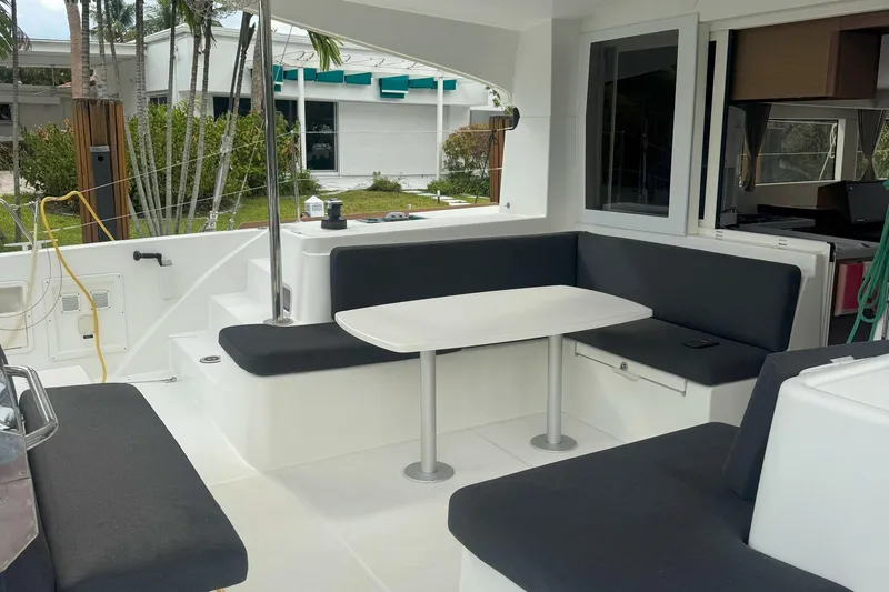 Keola Yacht Photos Pics Outdoor seating area on a 2022 Lagoon 40 catamaran, featuring a table and cushioned benches.