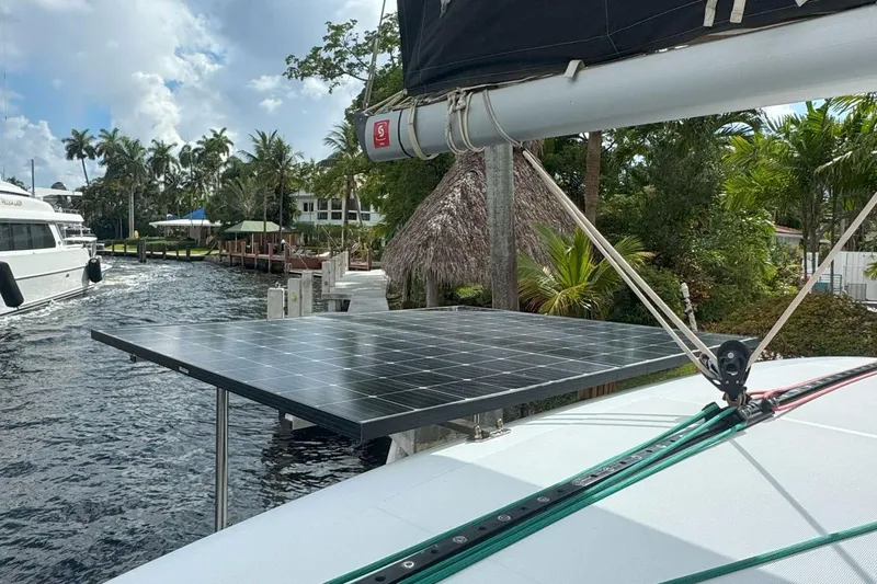 Keola Yacht Photos Pics 2022 Lagoon 40 catamaran with solar panels docked by tropical waterfront.