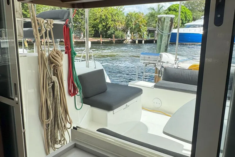 Keola Yacht Photos Pics 2022 Lagoon 40 catamaran interior view with ropes and seating, docked by water.