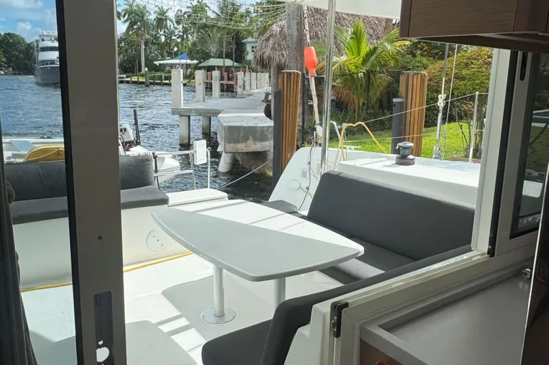 Keola Yacht Photos Pics Interior view of 2022 Lagoon 40 catamaran with outdoor seating and waterfront backdrop.